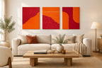 Triptyque abstrait texturé orange et bordeaux au-dessus d’un canapé écru, dans une mise en situation de décoration murale