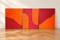 Triptyque abstrait orange et bordeaux composé de trois tableaux texturés en relief, avec détails à la feuille d’or